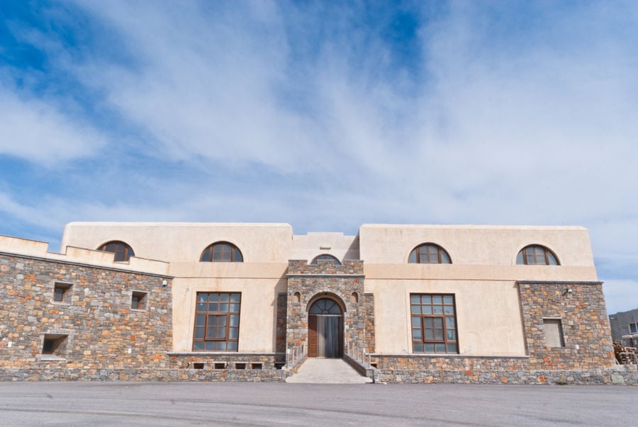 entrance of 'Ktima Toplou' monastery with stone walls and stone pavement in front